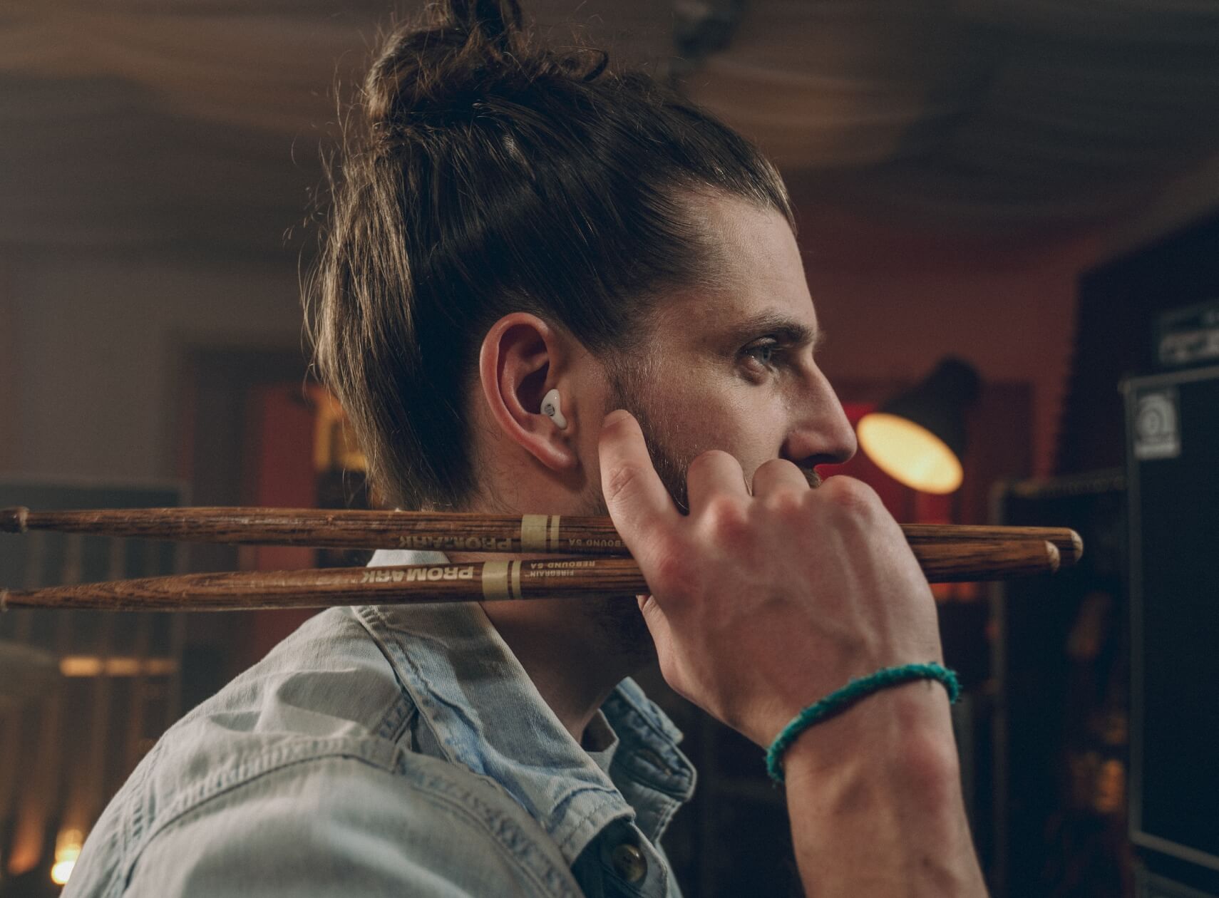 Junger Schlagzeuger trägt weißen In-Ear-Gehörschutz - Hörschutz für laute Musik